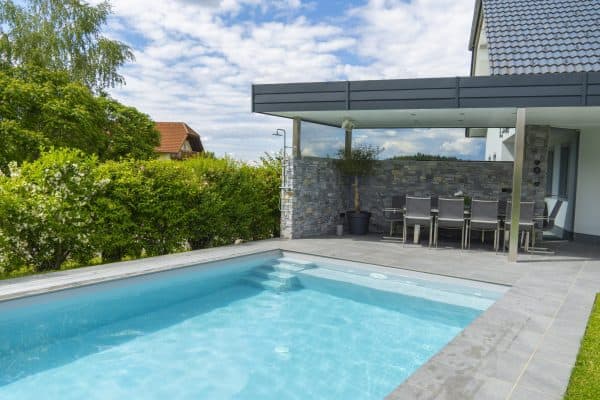 Privatpool mit moderner Terrasse und Blick auf den Garten.